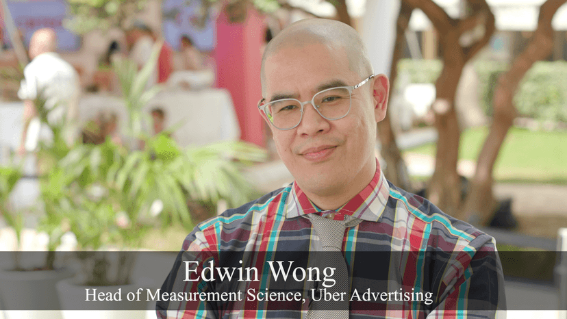 Edwin Wong in front of outdoor foliage.