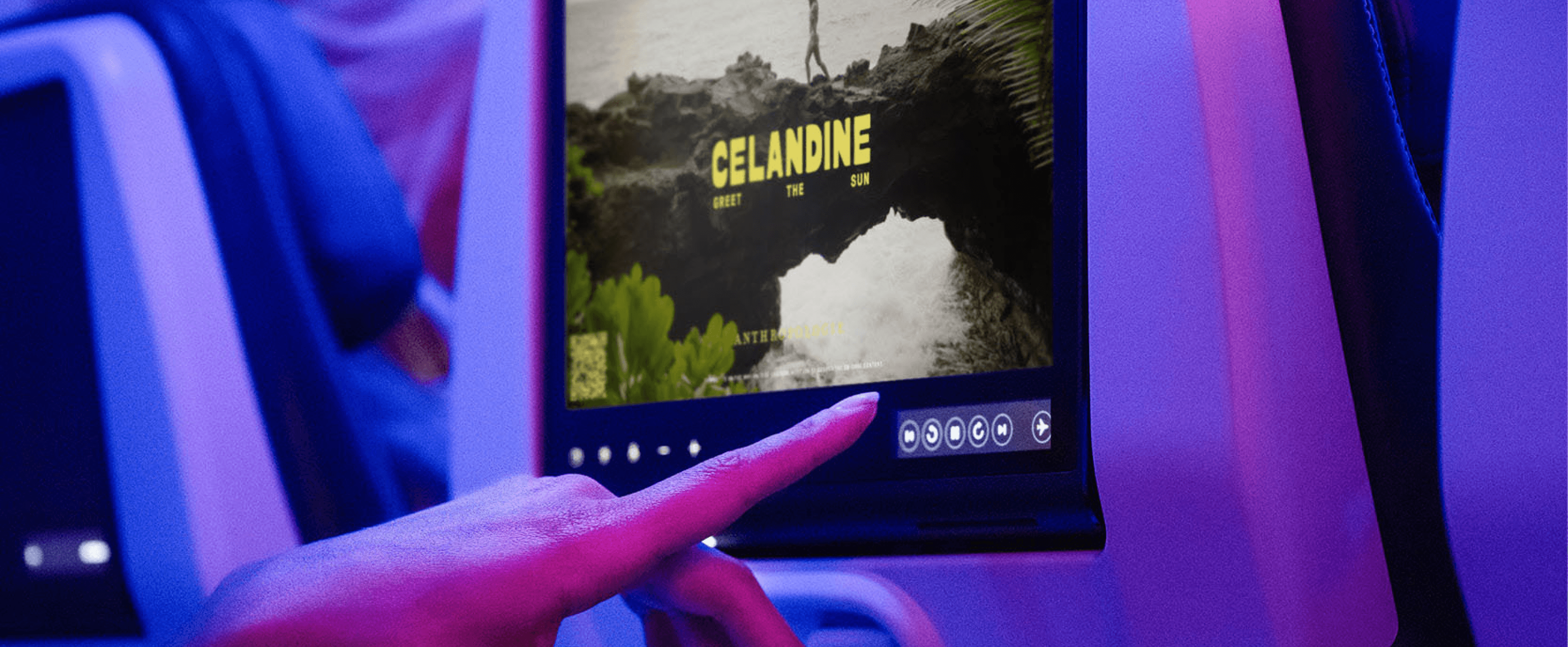 A traveler interacts with inflight entertainment content on a seatback screen.