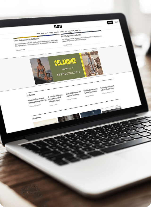 A laptop displaying a website featuring Anthropologie's Celandine collection banner with beach vacation imagery and resort wear.