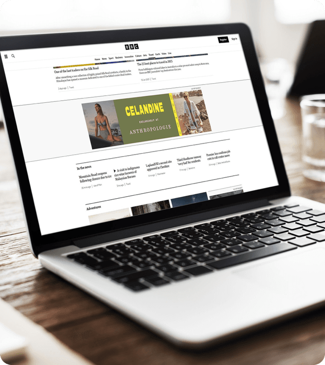 A laptop displaying a website featuring Anthropologie's Celandine collection banner with beach vacation imagery and resort wear.