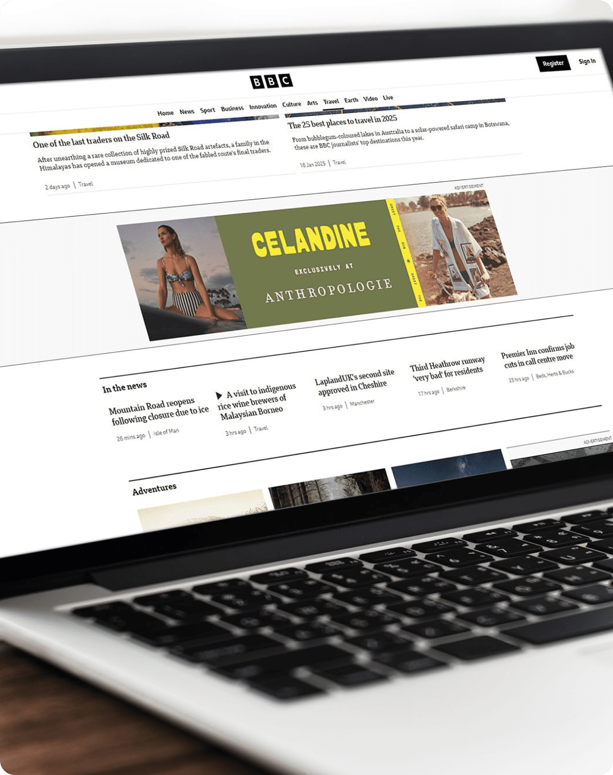 A laptop displaying a website featuring Anthropologie's Celandine collection banner with beach vacation imagery and resort wear.