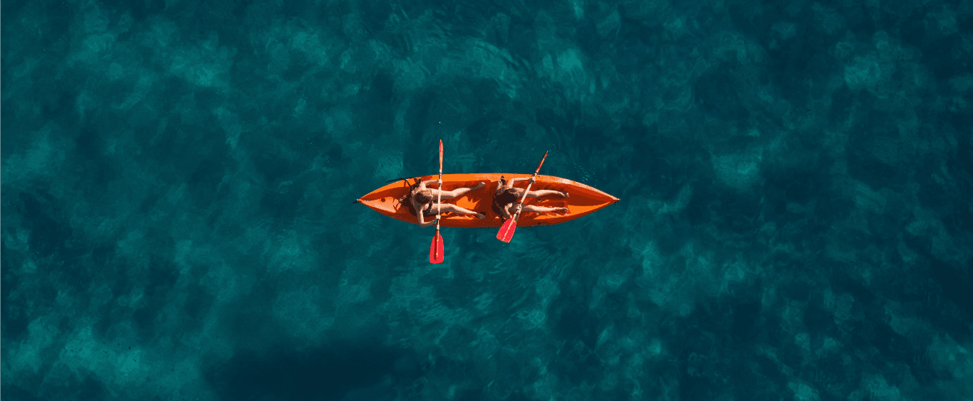 Summer travelers kayaking in blue waters