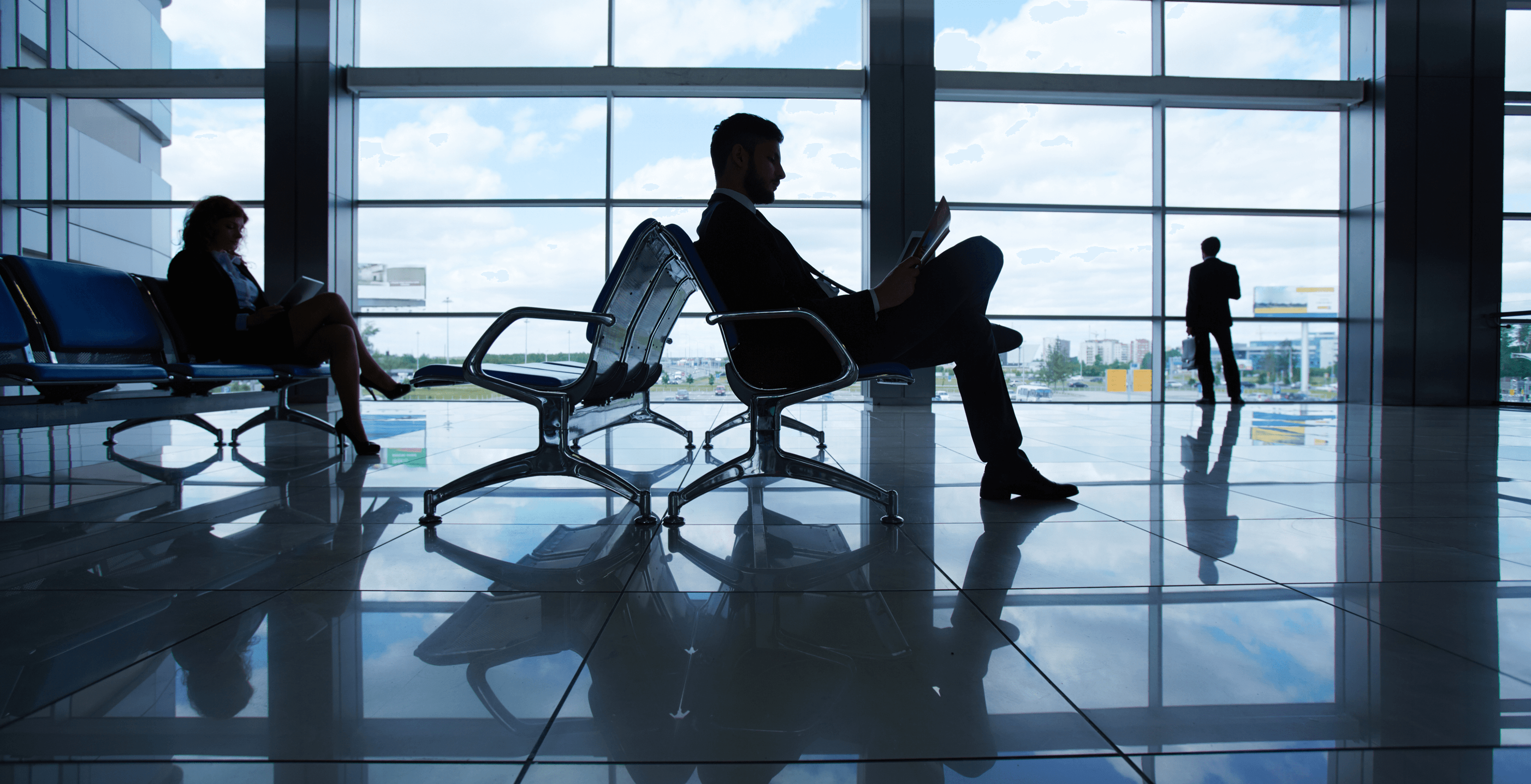 Man at airport reading a newspaper
