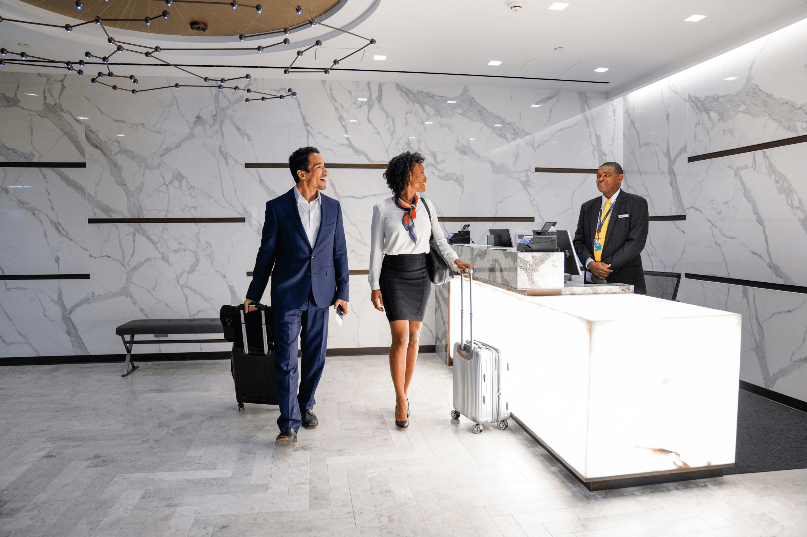 Two travelers talking to an airport agent.