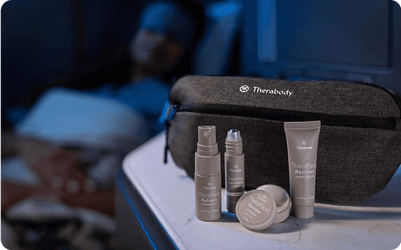 A Therabody amenity kit next to a United Polaris business class seat.