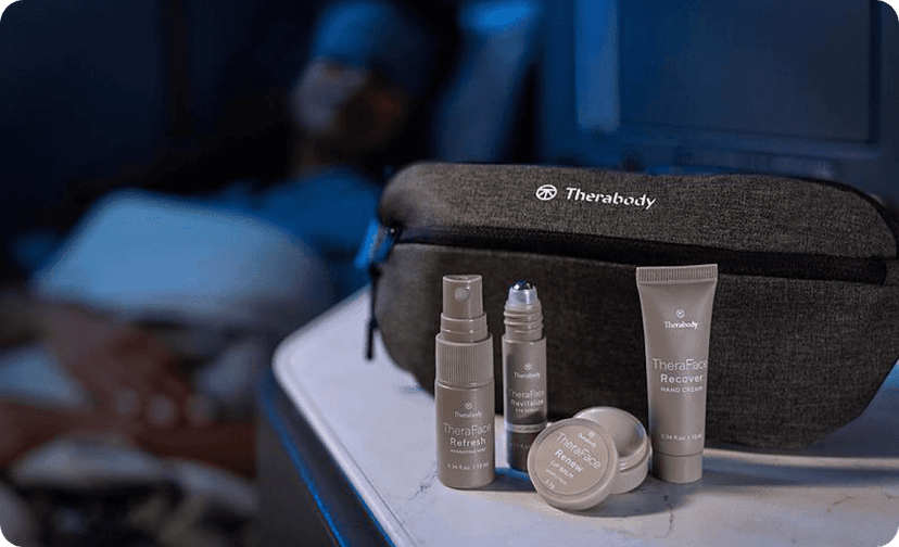 Premium amenity kit display with branded products on a tray table in an aircraft cabin